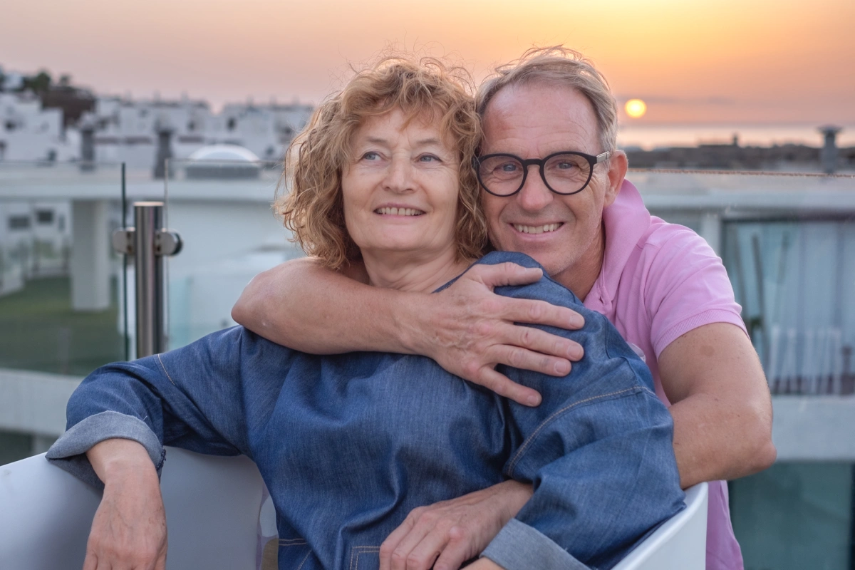 Retired couple in Greece on the terrace of their home at sunset