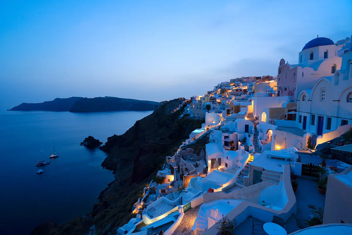 Traditional greek village Oia of Santorini, with blue domes of churches and village roofs at night