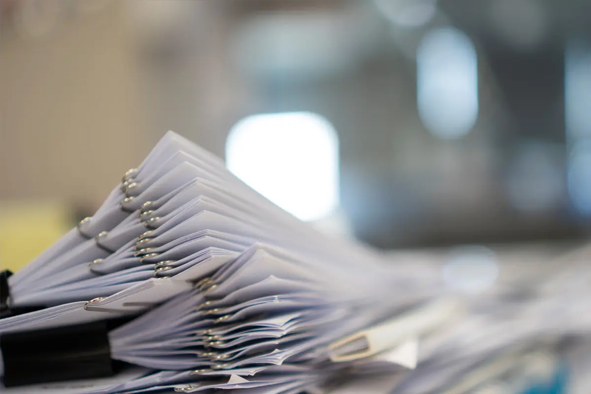 Pile of white documents in a workplace setting